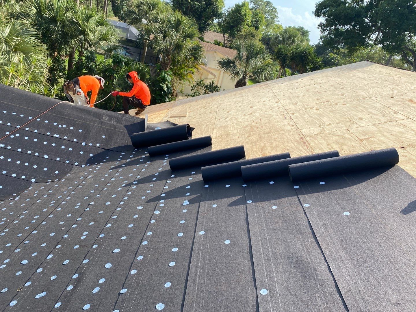 Standing seam metal panels staged over underlayment