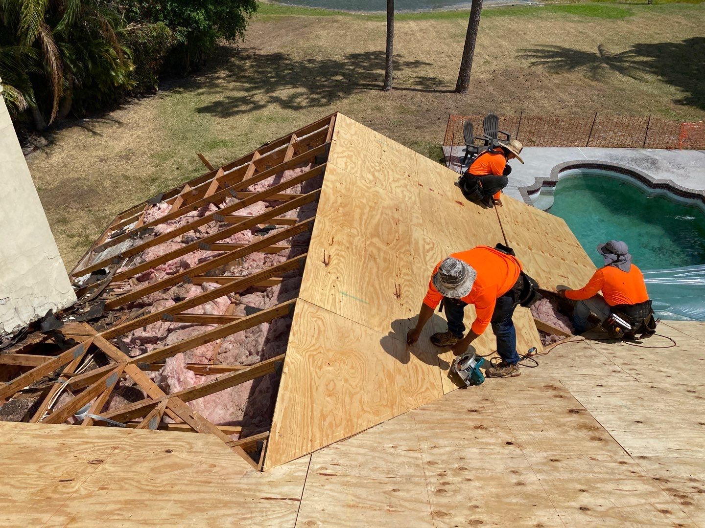 Crew installing new plywood roof decking