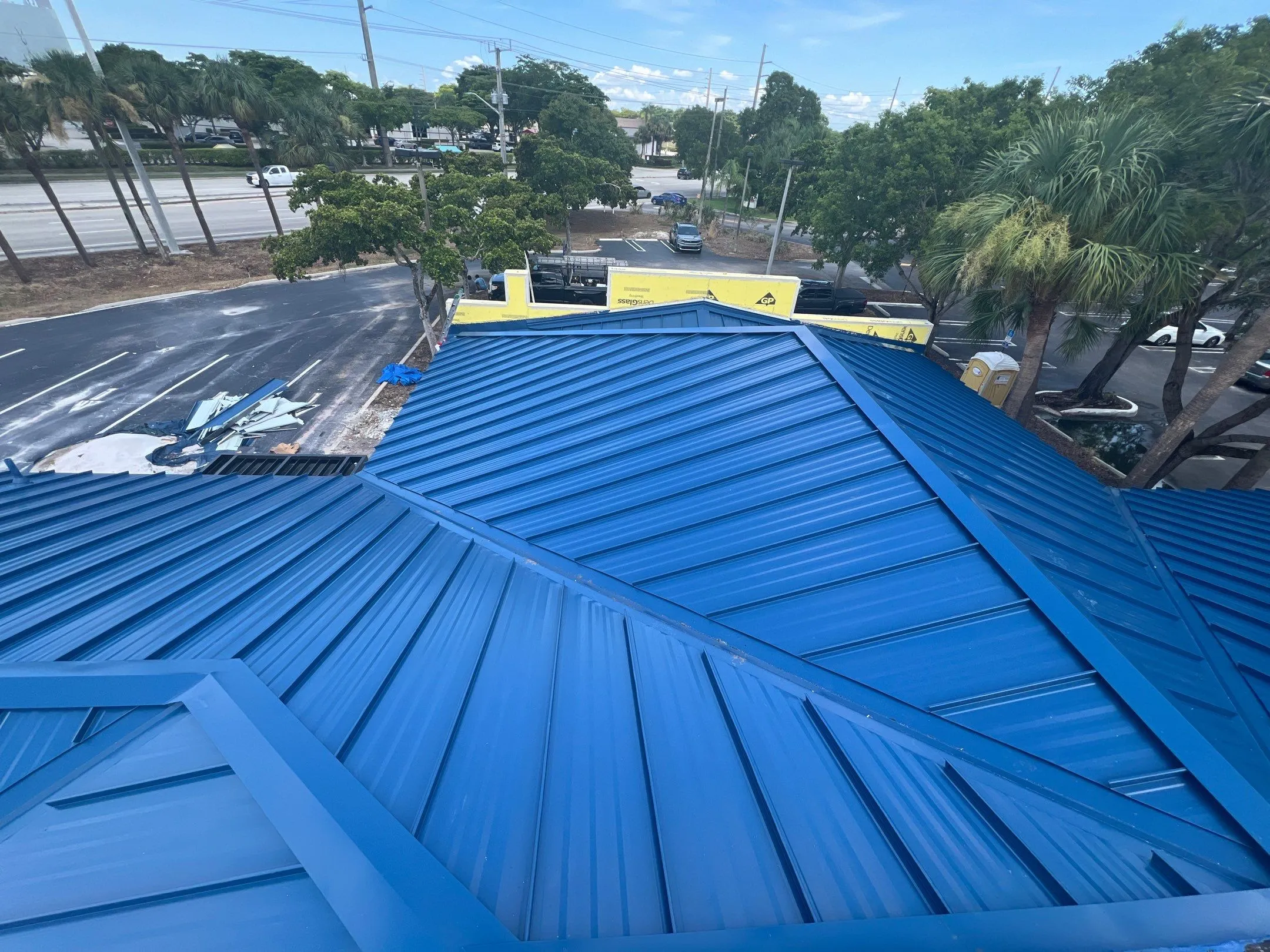 Blue standing-seam metal roof installed on a South Florida commercial building