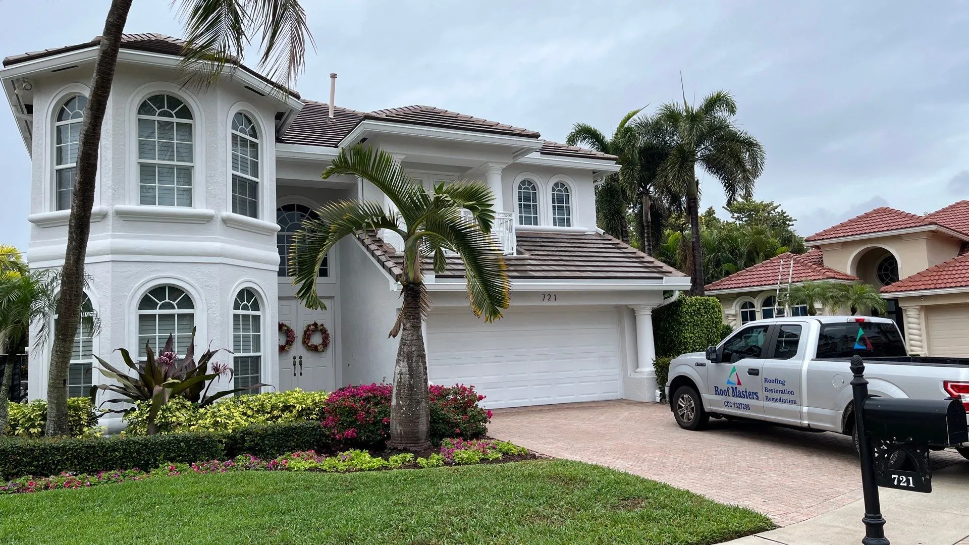Completed tile roof replacement on a South Florida home with a Roof Masters truck outside