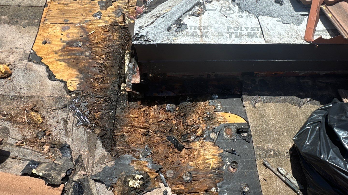 Deteriorated plywood exposed beneath the tile roof at the valley repair area in Delray Beach